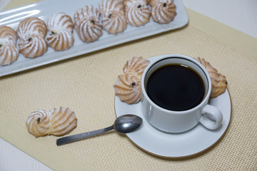 Coffee beans, a coffee grinder and a cup of hot coffee.