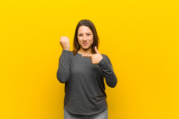 latin american woman looking impatient and angry, pointing at watch, asking for punctuality, wants...