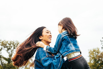 Mother playing with her daughter in park