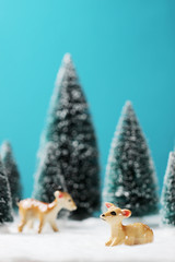 Christmas background with deers and blurred christmas trees on table.