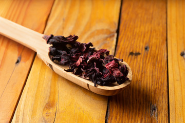 Dried flowers of hibiscus in wooden spoon