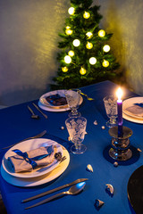 Christmas table setting with christmas tree in background