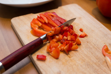 Paprika schneiden mit Messer auf Holzbrett