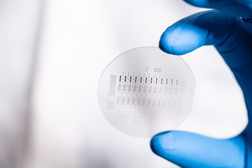 blue gloved hand holding computer chip