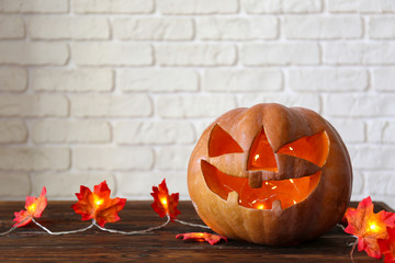 Orange pumpkin carved into Jack o Lantern on wooden table. Background, copy space, close up, top...