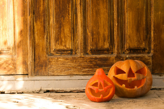 Few Orange Pumpkins Of Different Size Carved Into Jack O Lantern On The Porch. Background, Copy Space, Close Up, Top View. All Hallows Eve Halloween Party Decoration. Trick Or Treat Concept.