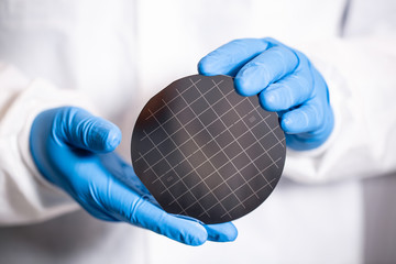 blue gloved hand holding computer chip