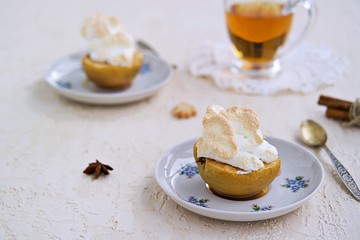 Autumn dessert, baked apples with meringue in retro style on a light concrete background. Thanksgiving Day. Harvest apples. Selective focus.