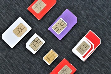 Close up of some international SIM cards from all over the world. Concept of international travel and roaming connection service.  