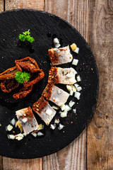 Marinated herring fillets on black stone