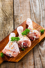 Raw chicken drumsticks on cutting board