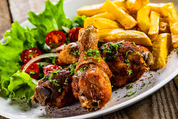 Grilled chicken drumsticks with french fries and vegetables