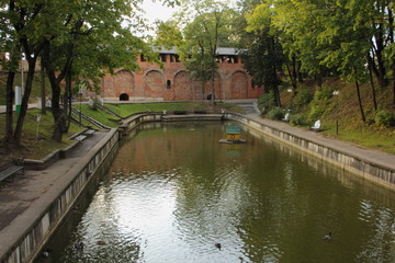 Fototapeta premium Smolensk, Russia, Pond in Park Lopatinsky Garden on ancient wortress wall background on summer day