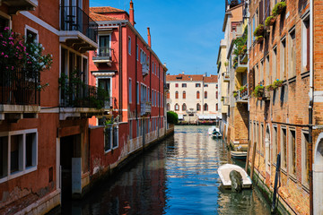 Fototapeta na wymiar Narrow canal with gondola in Venice, Italy