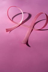 Women's health. Pink bow, double on pink background. Vertical. Space for your text. October Brazilian rose. October American rose. World campaign prevention, awareness to control breast cancer. Breast