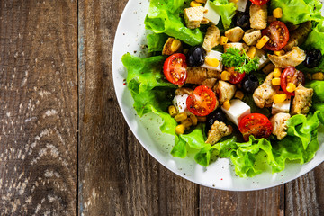 Caesar salad white plate on wooden table