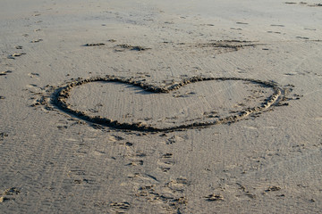 Drawn heart on sandy beach