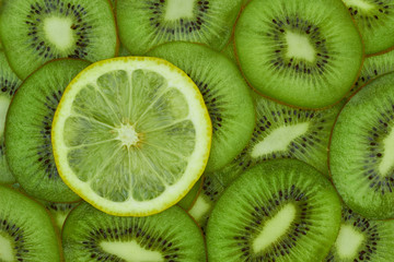 Fototapeta na wymiar Sliced kiwi and one lemon slice for textural background, top view, flat lay. Not like others concept.