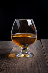 glass with whiskey on black background