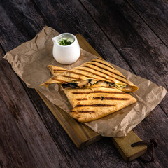 Set of tortilla quesadillas with turkey, mushrooms and souce on wooden background. Healthy food concept in rustic style
