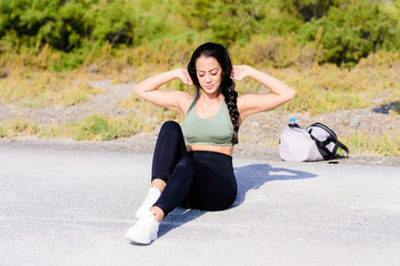 A shot of an athlete doing sit-ups outside