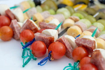 Set of delicious canapes , closeup. Many canapes with sausage, cheese and red tomato on a plate
