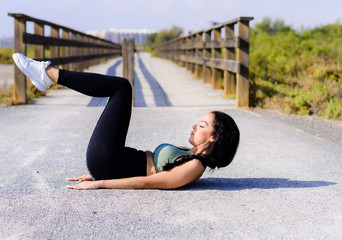 A shot of an athlete doing sit-ups outside