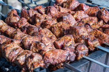 Grilled kebab cooking on metal skewer closeup. Roasted meat cooked at barbecue. BBQ fresh beef meat chop slices. Traditional eastern dish, shish kebab