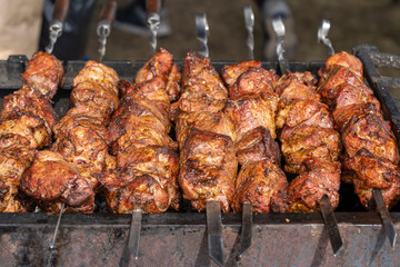 Grilled kebab cooking on metal skewer closeup. Roasted meat cooked at barbecue. BBQ fresh beef meat chop slices. Traditional eastern dish, shish kebab