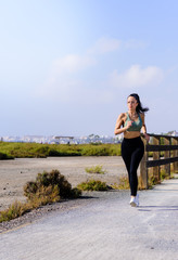 Happy sporty woman jogging outdoors