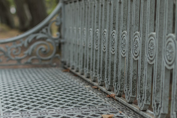 An impressive pattern of a metal bench somewhere in the park