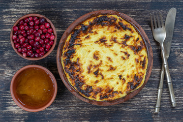 Sweet cottage cheese casserole with raisins and semolina on wooden table. Ceramic bowl with baked cottage cheese casserole , closeup, top view