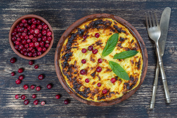 Sweet cottage cheese casserole with raisins and semolina on wooden table. Ceramic bowl with baked cottage cheese casserole , closeup, top view