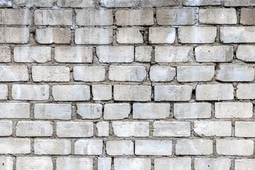 Vintage and dirty white brick wall background texture with smudges and cracks