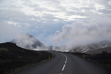 Beautiful asphalt road leading to hot steam columns