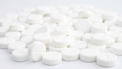 White pills on white background. Pile of tablets	