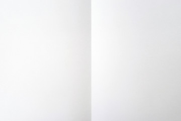 Blank white sheet of paper folded in half. White background. Place for text, copy space