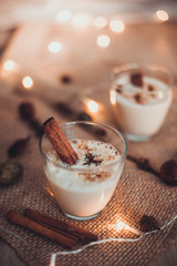 Eggnog in glasses with star anise and cinnamon on wooden table for Christmas and winter holidays. Copyspace included. - 292410694