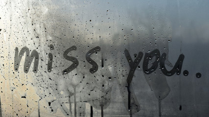 Miss you text. Inscription on sweaty window. Written message on steamy window. 
