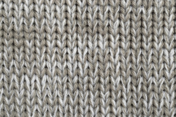 White and light brown melange yarn fabric knitted texture. Marl wool knitting background. Closeup 