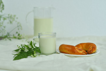 Glass jug pitcher of fresh milk with glass and croissant on white background.Milk concept