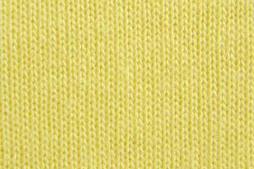 Yellow knitted background. Jersey texture. Closeup