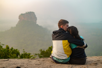 A couple in love on a rock admires the beautiful views. A couple in love travels. Couple in Sri Lanka. Honeymoon in Asia. Wedding travel