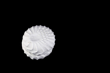 White marshmallow (zephyr) sprinkled with powdered sugar isolated on black. Top view