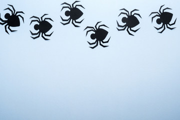 Happy halloween holiday concept. Halloween paper decorations, scary spiders on blue background. Flat lay, top view, overhead.