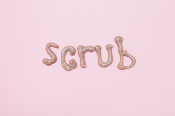 word scrub made of brown skin scrub on a pink background