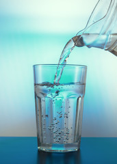 Glass with water and jug .