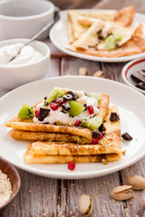 Thin Crepes with melted chocolate, sesame seeds, pomegranate and almonds. Tasty thin pancakes
