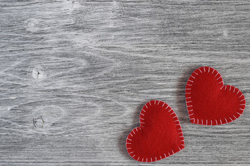 Valentine day background. Two red felt handmade hearts on a gray wooden background. Top view. Flat lay