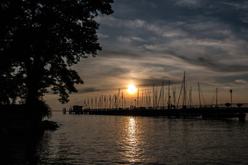 Golden sunset above the lake or the sea near the landing pier